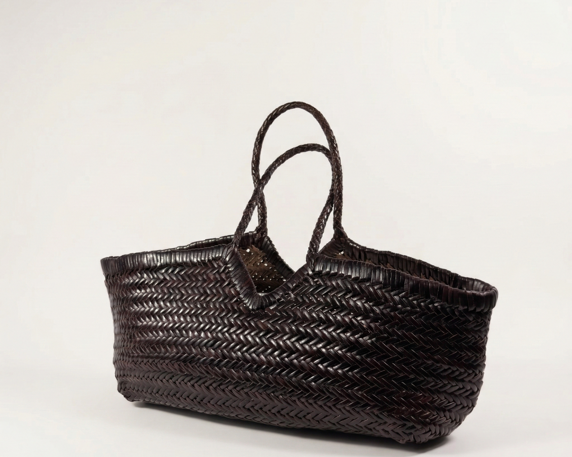 Angled view of the CASSIA woven leather shoulder bag in dark brown