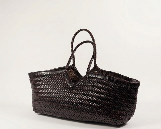 Woven brown handbag on a off white background