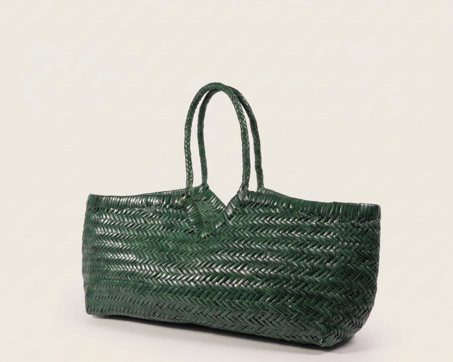 Angled view of the ELETTA woven leather shoulder bag in deep green