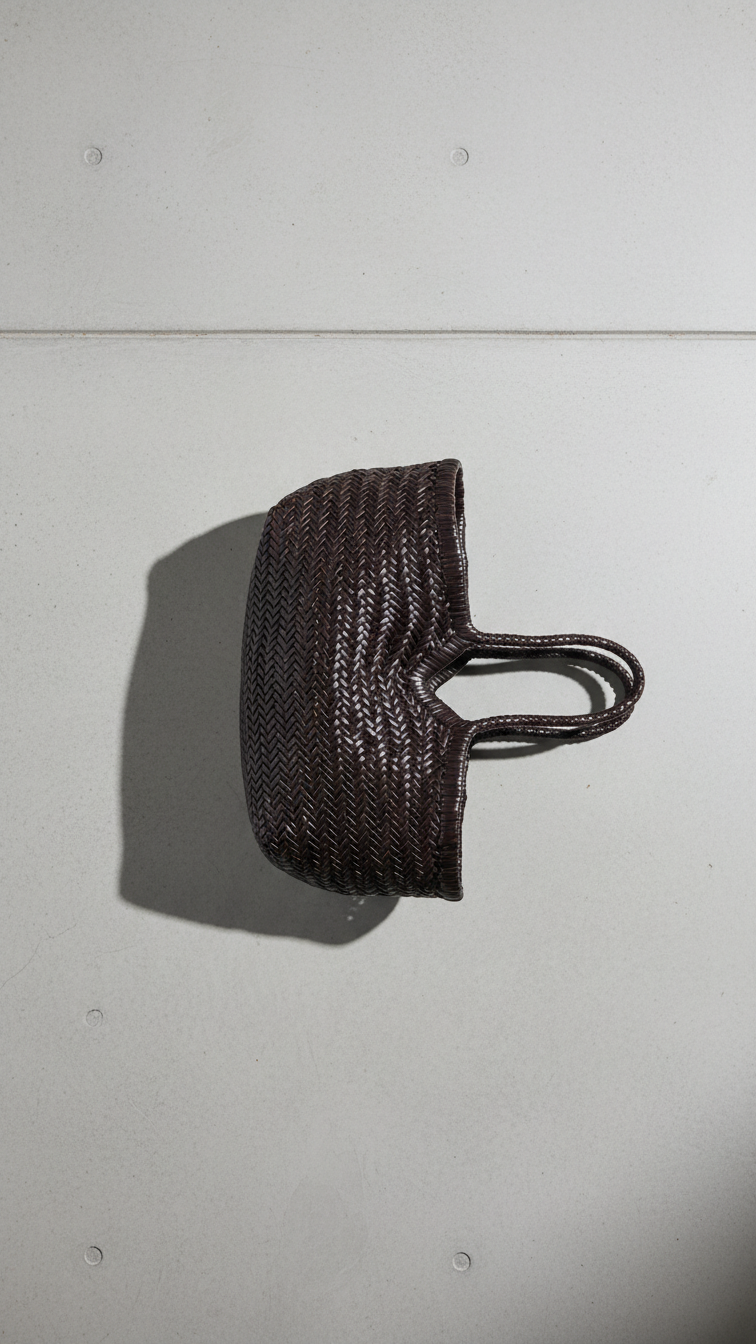 Black woven handbag on a light gray surface